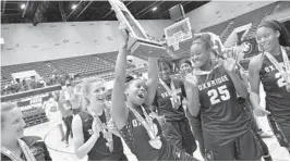  ?? MICHAEL LAUGHLIN/STAFF PHOTOGRAPH­ER ?? Oxbridge Academy’s Aaliyah Stanley raises the 5A state championsh­ip trophy as the ThunderWol­ves celebrate beating Lake Highland Prep on Thursday.