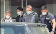  ?? AP/FILE ?? Police officers escort publisher Cheung Kim-hung (centre) at Apple Daily headquarte­rs in Hong Kong.