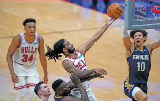  ?? GERALD HERBERT/AP ?? Bulls guard Coby White drives to the basket between Pelicans center Jaxson Hayes (10) and forward Zion Williamson during the second half.