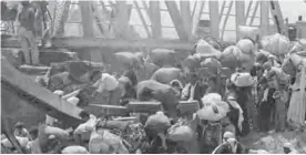  ??  ?? In this June 22, 1967 file photo, Palestinia­n refugees carry their belongings as they prepare to cross the wrecked Allenby Bridge over the Jordan River from the Israeli-occupied section of Jordan.