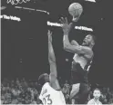  ?? ROB SCHUMACHER/THE REPUBLIC ?? Suns center Deandre Ayton shoots over the Warriors’ Draymond Green at Footprint Center on Tuesday.