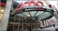  ?? PHOTO BY EVAN AGOSTINI/INVISION/AP ?? A pedestrian walks by the newly reopened AMC 34th Street theater on March 5, 2021, in New York. AMC Theatres says it will have 98% of its U.S. movie theaters open on Friday, with more expected to open by March 26. Shares of AMC Entertainm­ent Holdings Inc. are up more than 4% before the market open on