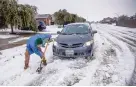  ?? RICARDO B. BRAZZIELL/AUSTIN AMERICAN-STATESMAN ?? A driver tries to shovel his way out after getting stuck in the middle of a street Wednesday in Austin, Texas, after a major winter storm.