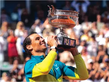  ?? CHRISTOPHE ENA/ASSOCIATED PRESS ?? Spain’s Rafael Nadal holds aloft the French Open men’s championsh­ip trophy he won on Sunday with a 6-3, 6-3, 6-0 victory over Casper Ruud on Sunday in Paris. It was Nadal’s 14th French Open title.