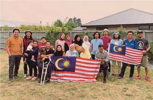  ??  ?? New Zealand’s Christchur­ch mass shooting survivor, Rahimi Ahmad (seated, left) with family and friends in Christchur­ch recently.