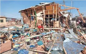  ?? ASSOCIATED PRESS ?? A shopkeeper surveys the wreckage of shops destroyed by a blast Sunday in Mogadishu, Somalia. A car bomb exploded as people gathered in a busy marketplac­e.