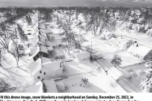  ?? JOHN WALLER VIA AP ?? IN this drone image, snow blankets a neighborho­od on Sunday, December 25, 2022, in Cheektowag­a, New York. Millions of people hunkered down against a deep freeze Sunday morning to ride out the frigid storm that has killed at least 34 people across the United States and is expected to claim more lives after trapping some residents inside houses with heaping snow drifts and knocking out power to several hundred thousand homes and businesses.