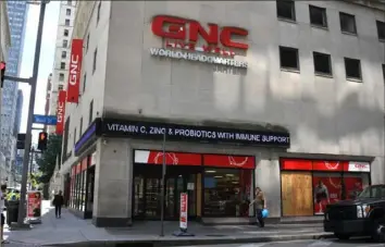  ?? Darrell Sapp/Post-Gazette ?? GNC World Headquarte­rs and its GNC Store at the corner of Wood Street and Sixth Avenue, Downtown, in June.