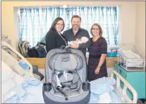  ?? SUBMITTED PHOTO ?? NLMA President Dr. Lynn Dwyer (right) presents a new car seat to parents Stephanie and Andy Harding following the birth of their daughter, Alyssa, as part of the NLMA’S annual car seat program.