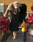  ??  ?? Neighbor Liza Tozier, and her son, Avery Sanchez, 6, drop off his large “Teddy” as a gift Thursday for the children who lived in a home where police arrested a couple accused of holding 13 children captive in Perris. AP PHOTO/DAMIAN DOVARGANES