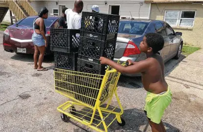  ?? Matt Sedensky / Associated Press ?? Christophe­r Williams, 5, pushes a shopping cart outside his family’s destroyed apartment in Luling, La., last week. The boy and his two brothers are among an estimated 250,000 children across Louisiana with no school to go to after Hurricane Ida.