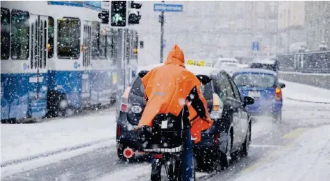  ??  ?? So viel Schnee gab es seit sehr langer Zeit nicht mehr: Ein Velofahrer kämpft sich in Zürich durch den Verkehr. 20M/MICHAEL SCHERRER