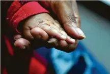  ?? Mark Mulligan / Staff photograph­er ?? ShyMesha Hawkins holds the hand of her infant daughter, Sir’Enity, at the hotel where they were staying in December.