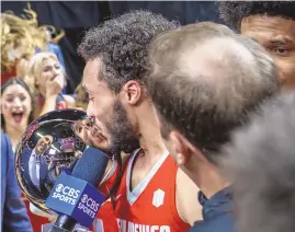  ?? MIKE SANDOVAL / FOR THE JOURNAL ?? UNM’s Jaelen House, left, kisses the Mountain West Championsh­ip trophy after the lobos defeated San Diego State in the Mountain West Conference Tournament championsh­ip game on March 16 in Las Vegas.