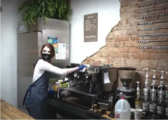  ?? — AFP photos ?? A coffee barista prepares wipes down a coffee machine at Reservoir Coffee in Norwood, North Carolina.