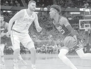  ?? PHELAN M. EBENHACK/AP ?? Orlando Magic forward Wes Iwundu tries to drive past Atlanta Hawks center Isaac Humphries during an April game. The Magic and Humphries reportedly have reached an agreement on an Exhibit 10 contract.