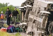  ?? CHARLIE RIEDEL AP ?? Luggage is scattered nearby as law enforcemen­t personnel inspect the scene of the crash.