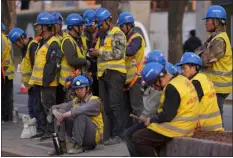  ?? NG HAN GUAN — THE ASSOCIATED PRESS ?? Workers wait for transport outside a constructi­on site in Beijing on Tuesday. China’s Finance Ministry has denounced a report by Fitch Ratings that kept its sovereign debt rated at A+ but downgraded its outlook to negative, saying in a statement that China’s deficit is at a moderate and reasonable level and risks are under control.