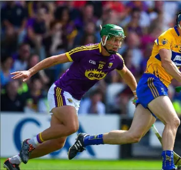  ??  ?? Clare full-back David McInerney breaking away from Wexford’s leading scorer from play, Conor McDonald.