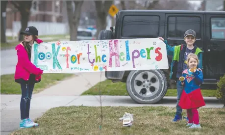  ?? DAX MELMER ?? Mckinley Nichols, 9, left, Elliot Nichols, 7, and Kate Nichols, 3, take part in a rally for the health-care staff at the Met Campus of Windsor Regional Hospital while outside their home on Chilver Road in South Walkervill­e on Friday.