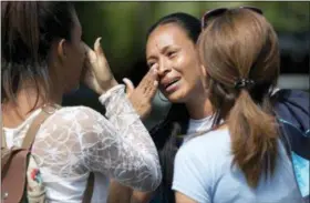  ?? ARIANA CUBILLOS — THE ASSOCIATED PRESS ?? Relatives cry Thursday after learning their loved ones died in a fast-moving fire a day prior that swept through a police station where prisoners were being kept in crowded cells in Valencia, Venezuela.