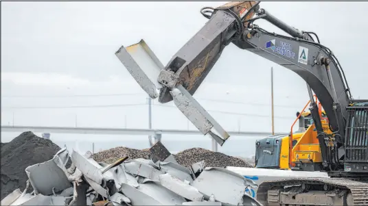  ?? Julia Nikhinson The Associated Press ?? Workers use a shearer to break apart salvaged steel from the collapsed Francis Scott Key Bridge on Friday at Sparrows Point, Md. The bridge collapsed after a wayward cargo ship crashed into it, causing it to crash into the harbor and killing six people.