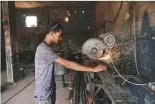  ?? Reuters ?? Rolling summer blackouts have have put the crimp on small businesses such as this workshop in Benghazi, Libya.