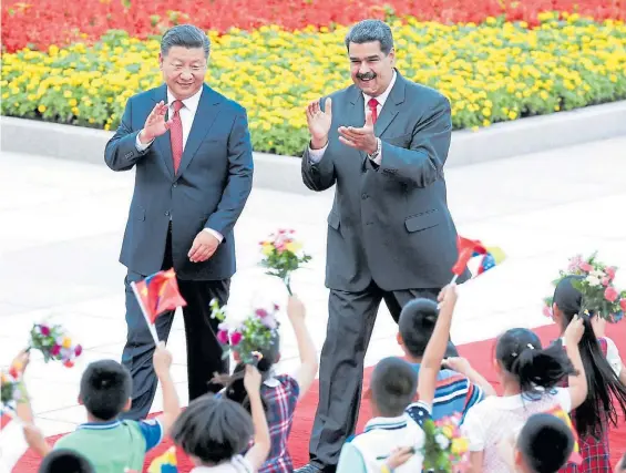  ?? AP ?? Saludo. El presidente chino Xi Jiping y su par venezolano, Nicolás Maduro, saludan a un grupo de chicos durante la ceremonia en Beijing.