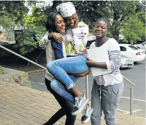  ?? Picture: Alon Skuy ?? Kuhle Ndlazi hugs her sister Gugu, centre, who achieved two distinctio­ns in her matric exams at Greenside High School. Another sister, Gabisile, looks on. The results were released on Friday.