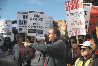  ?? Scott Olson / Getty Images ?? Chicago public school teachers picket outside of Lane Tech College Prep high school. About 25,000 teachers are on strike. Chicago has the nation’s thirdlarge­st public school system.