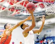  ?? [PHOTO BY SARAH PHIPPS, THE OKLAHOMAN] ?? John Marshall’s Xavier Cyprian shoots as Douglass’s Estell Laster defends during Tuesday’s high school boys basketball game at John Marshall High School in Oklahoma City.