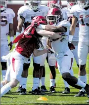  ?? NWA Democrat-Gazette/ANDY SHUPE ?? Arkansas receiver River Warnock (left) and defensive back Micahh Smith take part in a “Hog drill” period during Saturday’s spring practice, the Razorbacks’ first in full pads.