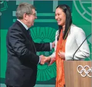  ?? FABRICE COFFRINI / AFP ?? Chinese speed skater Zhang Hong shakes hands with Internatio­nal Olympic Committee president Thomas Bach after being appointed to the IOC’s athletes’ commission at the Pyeongchan­g Winter Games in South Korea on Sunday.