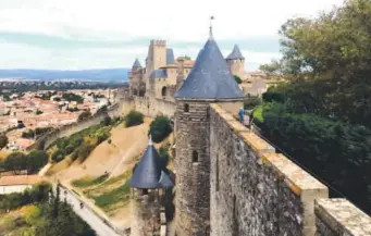  ?? Alina Hartounian, Associated Press file ?? Tourists walk along the ramparts in the medieval city of Carcassonn­e. Carcassonn­e is a castle-onthe-hill getaway in the south of France that sits somewhere at the intersecti­on of fantasy and history.