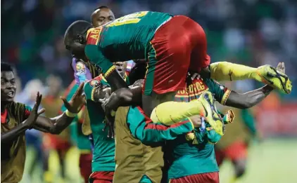  ??  ?? Cameroon’s Christian Mougang Bassogog, obscured below right, and teammates celebrate after he scored a goal against Ghana during the African Cup of Nations semi-final football match between Cameroon and Ghana on Thursday (AP Photo/Sunday Alamba)