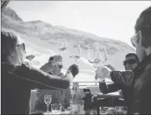  ?? ?? With snow-capped mountains in the background, skiers enjoy winding down over food and drinks at the end of a busy day skiing in the Austrian resort of Ischgl.