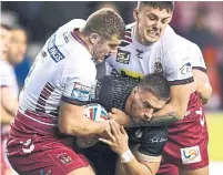  ?? GARETH COPLEY GETTY IMAGES ?? Toronto’s Matty Russell is tackled by Wigan’s Ollie Partington and Tony Clubb during Thursday’s game in Wigan, England.