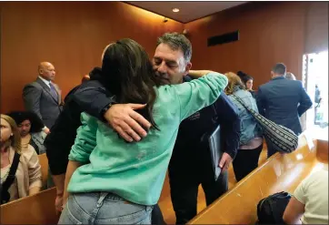  ?? PHOTOS BY CARLOS OSORIO – THE ASSOCIATED PRESS ?? Buck Myre hugs Reina St. Juliana, Hana St. Juliana’s sister, after the sentencing of James and Jennifer Crumbley on Tuesday in Pontiac.