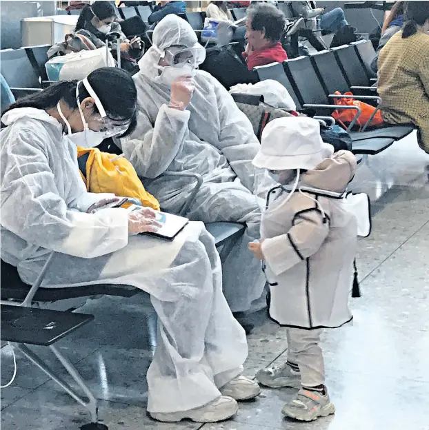  ??  ?? Travellers sporting protective clothing in the departure lounge at Heathrow Airport Terminal 2 in London yesterday