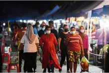  ?? — Bernama ?? Being careful: People wearing face masks and observing social distancing at the Cenderawas­ih night market in Kuantan, Pahang.