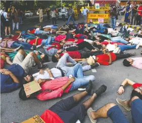 ?? RAKASH SINGH / AFP VIA GETTY IMAGES ?? Climate activists lie on the ground to perform a die-in action as part of global protests advocating for emissions cuts in New Delhi last week.