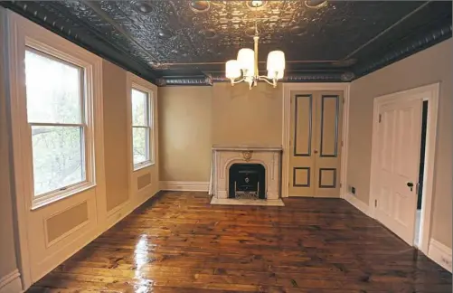  ?? Nate Guidry/Post-Gazette photos ?? The master bedroom has an original tin ceiling, fireplace mantel and pine floor, all restored.