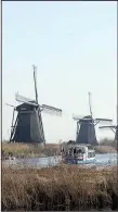  ?? AP/PETER DEJONG ?? Windmills lining the Hooge Boezem van de Overwaard canal at the UNESCO World Heritage site in Kinderdijk, Netherland­s, are major draws for tourists.