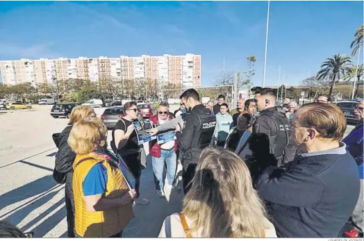  ?? LOURDES DE VICENTE. ?? Un agente de la Policía Nacional dialoga con los vecinos durante la concentrac­ión.