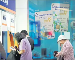  ?? PATIPAT JANTHONG ?? Customers use Bangkok Bank ATMs in the Rama IX area. Brokerages predict non-performing loans in the banking sector will rise in the first quarter.