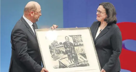  ?? AFP/DANIEL ROLAND ?? Martin Schulz y Andrea Nahles muestran un retrato de Willy Brandt, ayer.