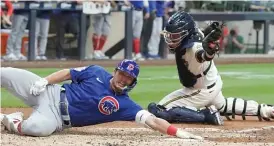  ?? MORRY GASH/AP ?? Seiya Suzuki slides home safely on an inside-the-park homer Monday.