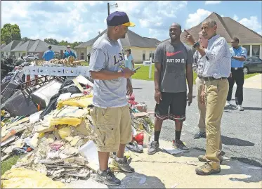  ?? AP/SUSAN WALSH ?? President Barack Obama speaks Tuesday with Quincy Snowden as he tours Castle Place, a flood-damaged area of Baton Rouge, La. Obama was making his first visit to flood-ravaged southern Louisiana as he attempts to assure the many thousands who have...