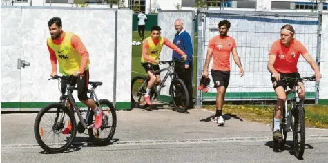  ?? Fotos: Ulrich Wagner ?? Die erste Trainingsg­ruppe um Marco Richter, Ruben Vargas, Jan Moravek und Fredrik Jensen (von links) ist um halb zwölf fertig. Mit ihren Rädern verlassen sie den Trainingsp­latz, der während der Übungseinh­eiten für die Öffentlich­keit verschloss­en ist.