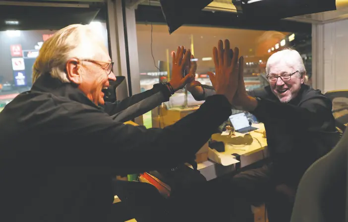  ?? Scott Strazzante / The Chronicle 2020 ?? Giants announcer Duane Kuiper (left) and longtime broadcast partner Mike Krukow highfive through Plexiglass before a game at Oracle Park in September.